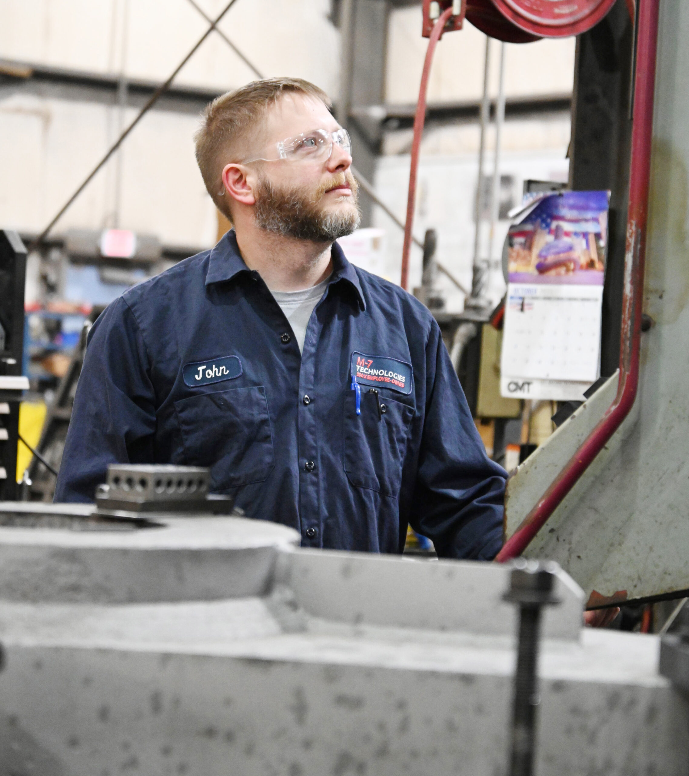 M-7 Technologies technician look at a screen up to his left