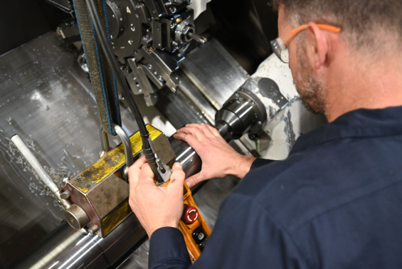 M-7 Technologies technician using a tool to manufacture a metal tube